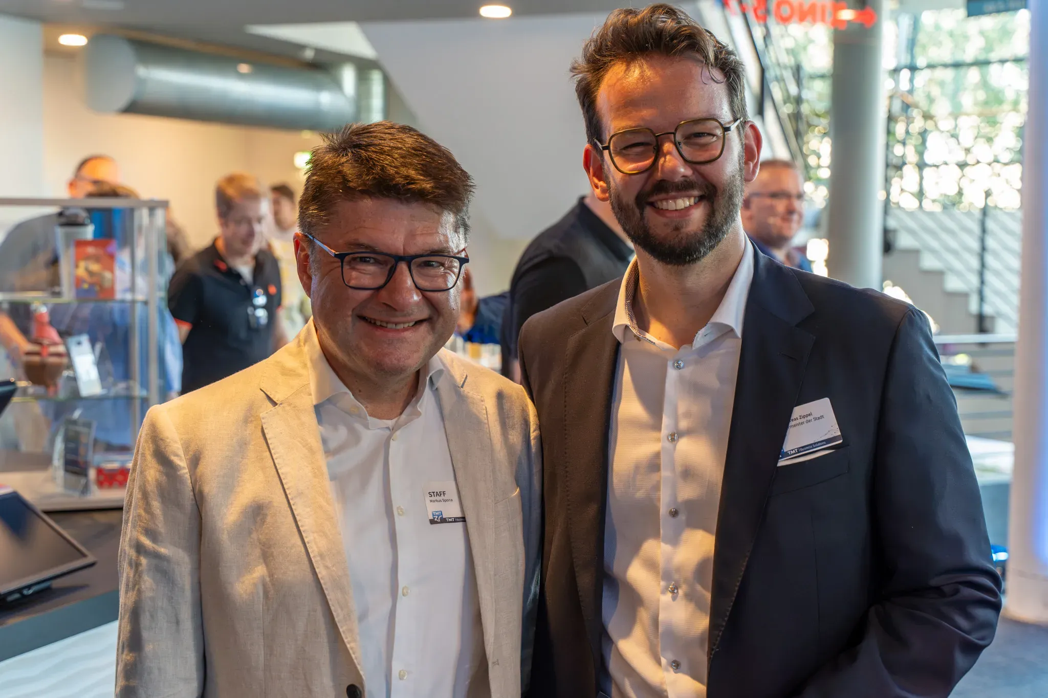 Zwei lächelnde Gäste im Foyer der Jubiläumsfeier