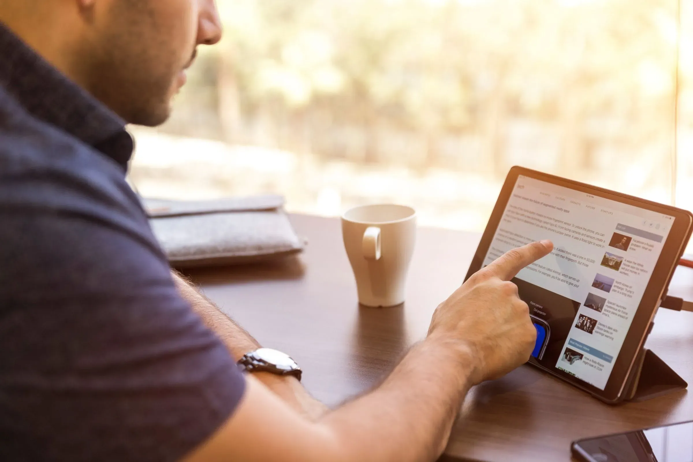 Mann sitzt mit Tablet am Schreibtisch