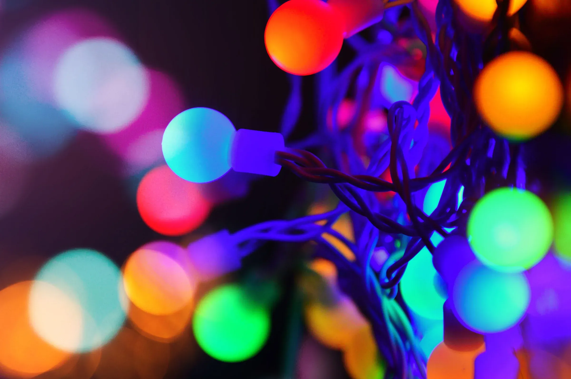 Verschwommene Weihnachtsbeleuchtung mit leuchtenden Kugeln und Lichterketten