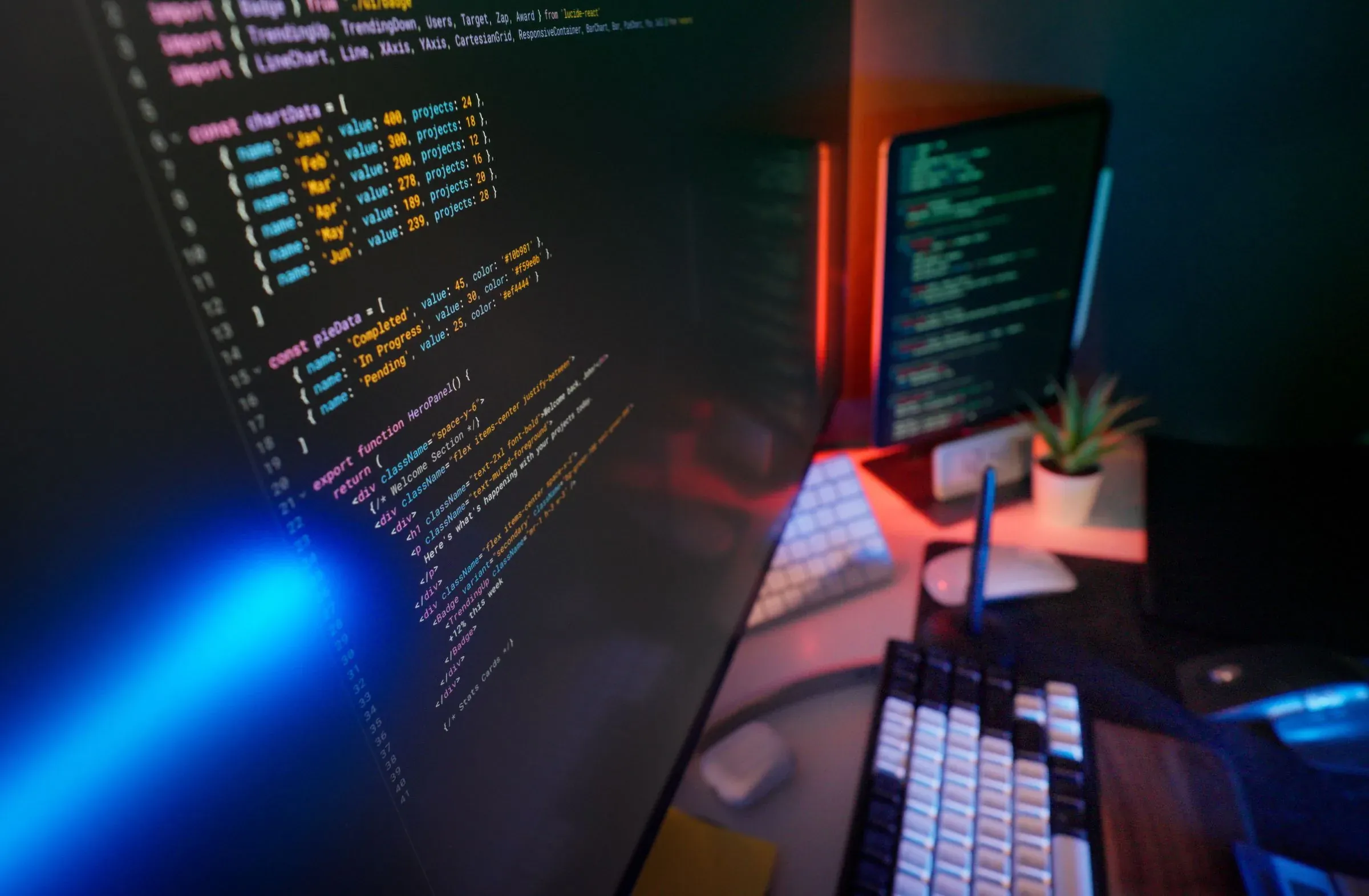 Bunt beleuchteter Computerarbeitsplatz mit mehreren Monitoren und Eingabegeraeten