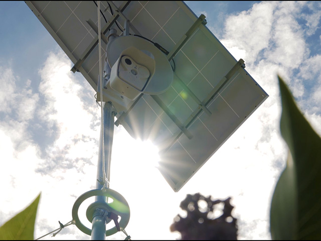 IT Service Webcam mit Solarpanel unter blauem Himmel